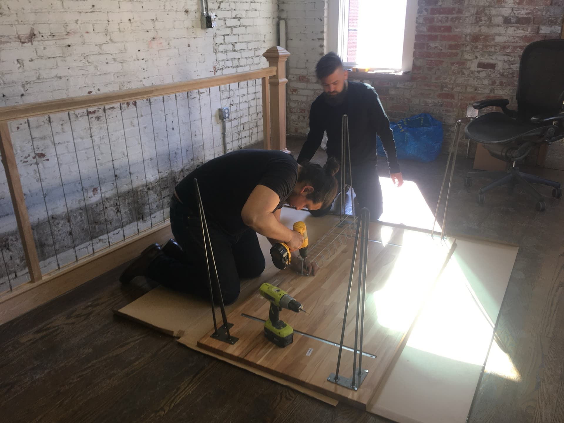 Abe and Greg installing hairpin legs onto the studio’s solid-wood tabletops.