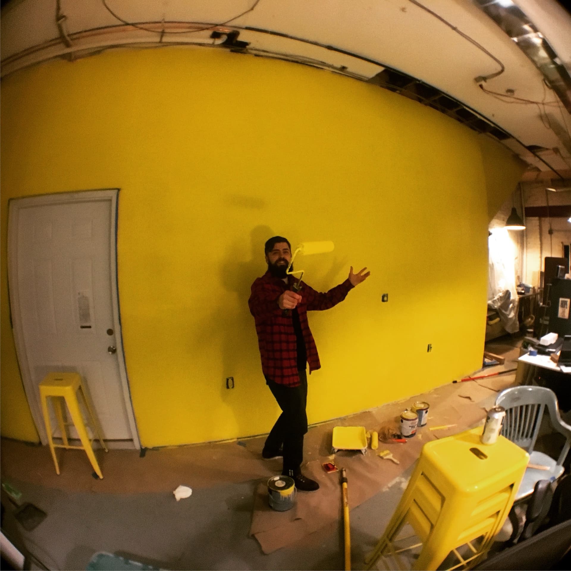 Greg rolling a yellow wall in the studio.