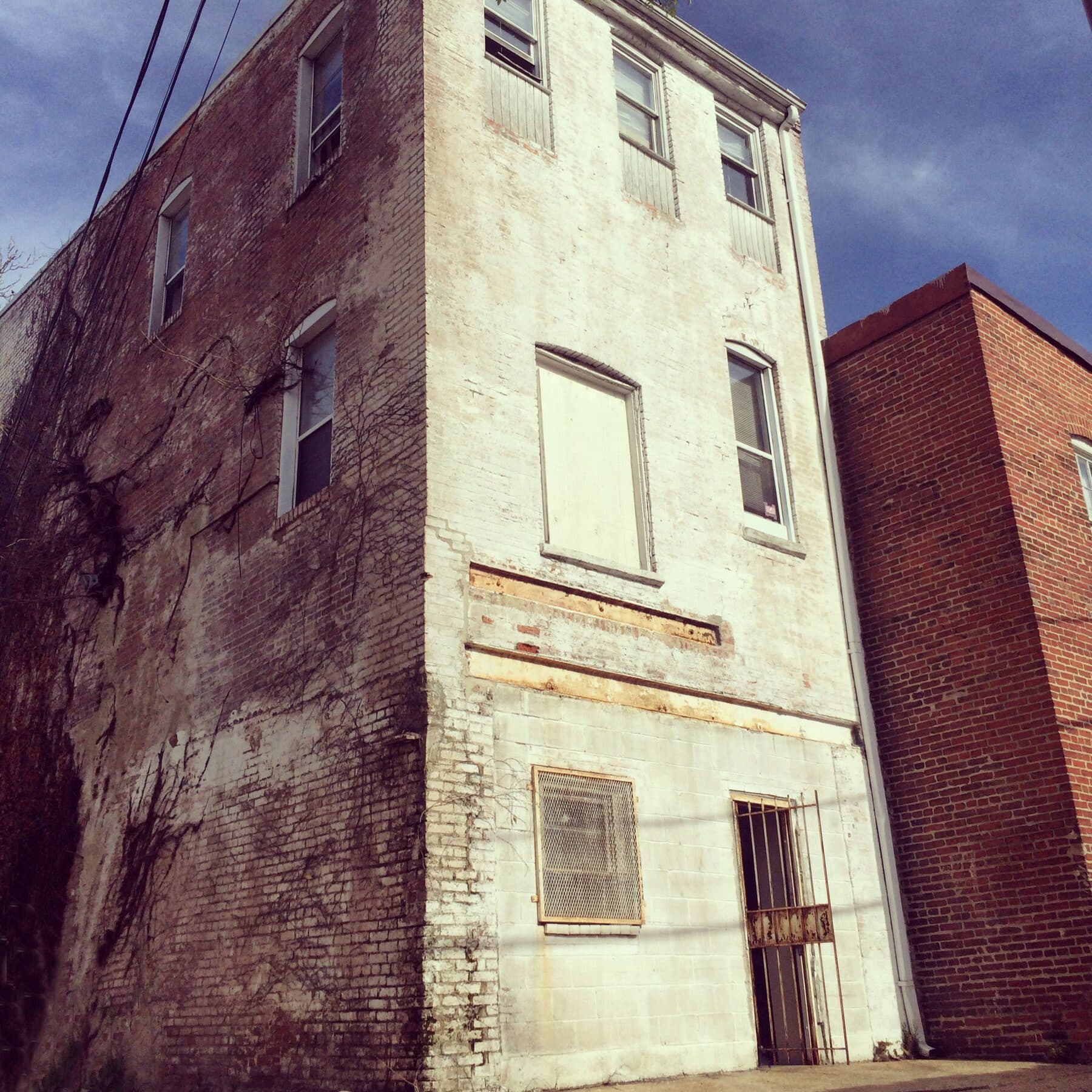 The brick and painted-stucco back of the DC carriage house seen from the alley before renovation.