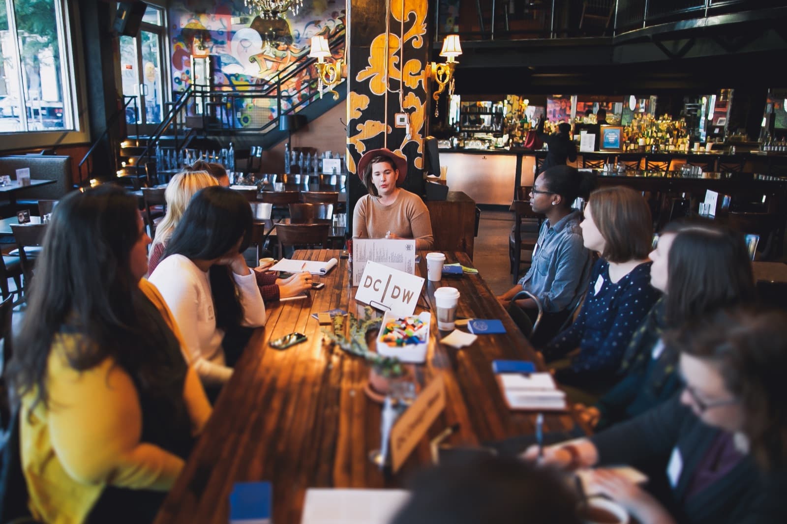 Long communal bar table with the DC|DW sign at the center, panelists gathered around at A Creative DC.