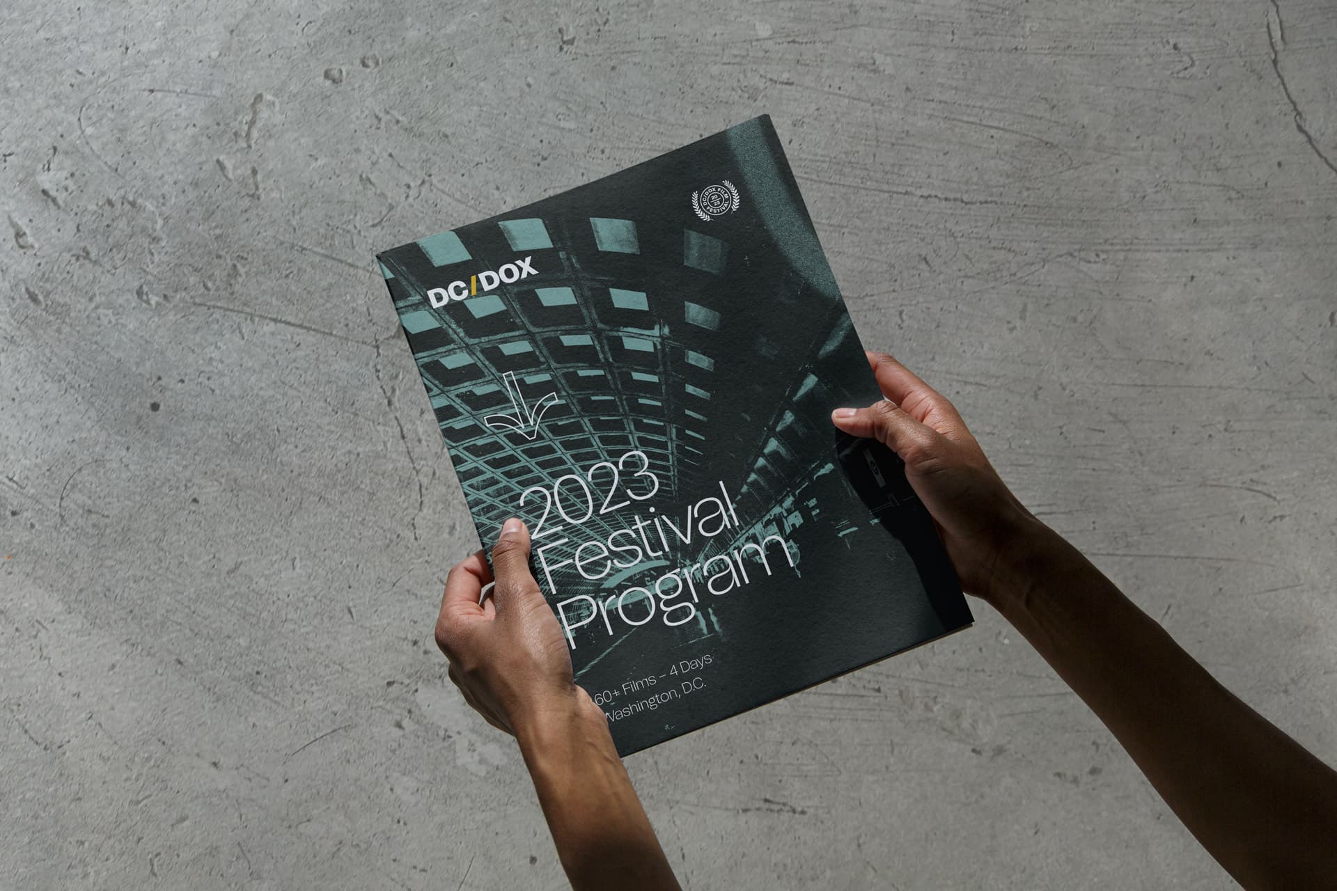 Hands holding the DC/DOX festival program