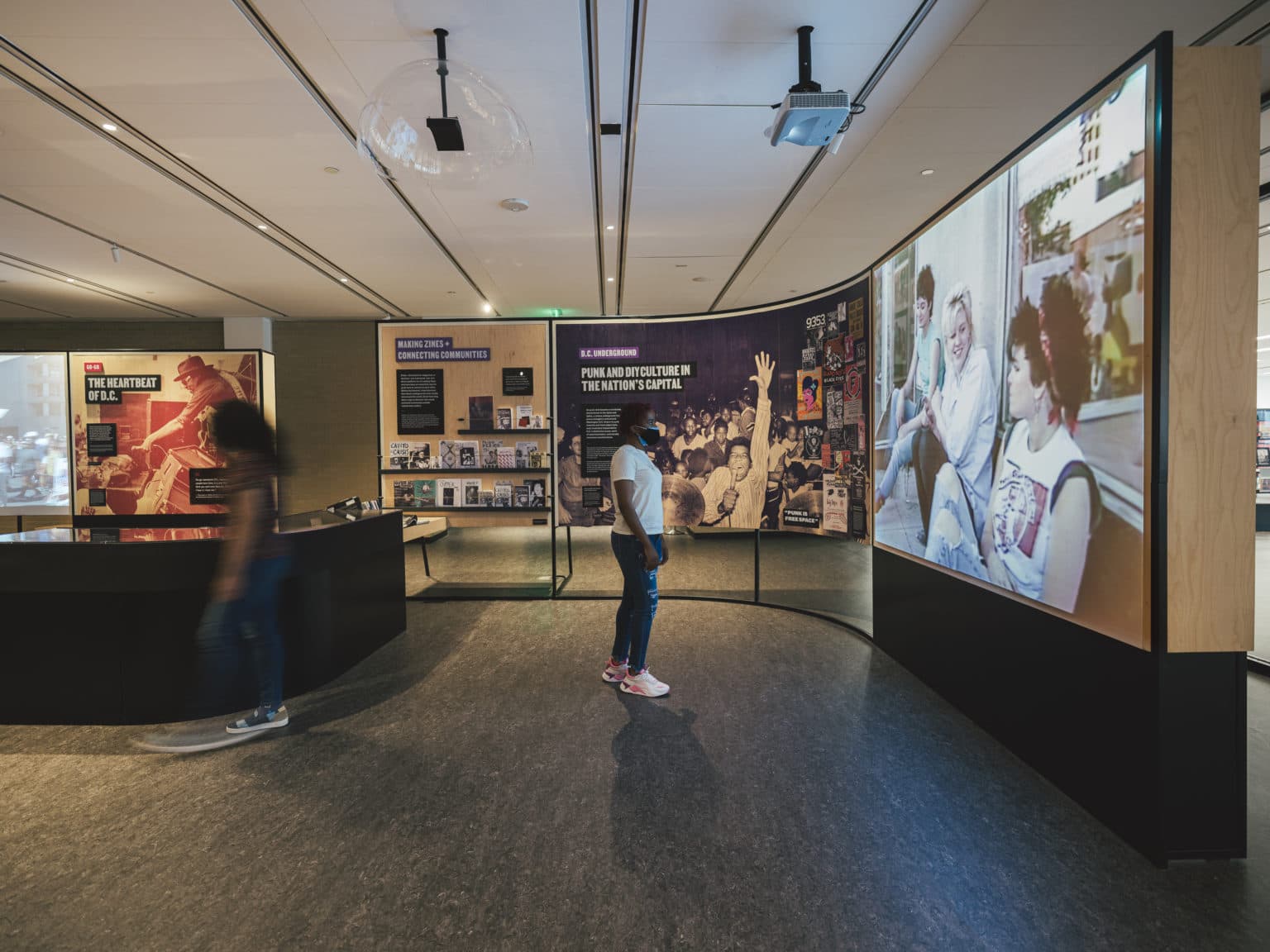 MLK Memorial Library exhibition, the Punk and DIY Culture wall with a wide video panel and curved zine display.