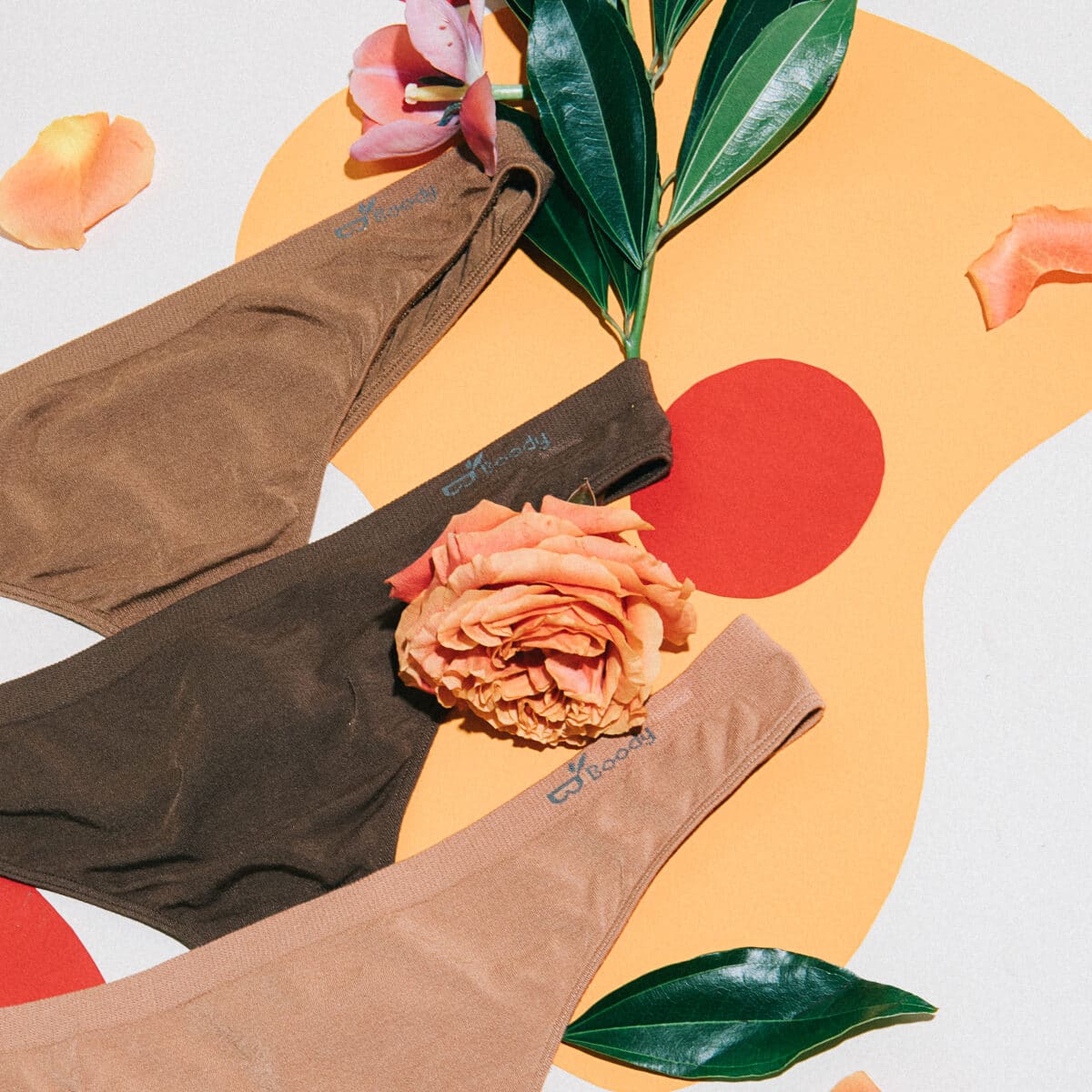 A brown set laid out with a rose over yellow and red painted shapes