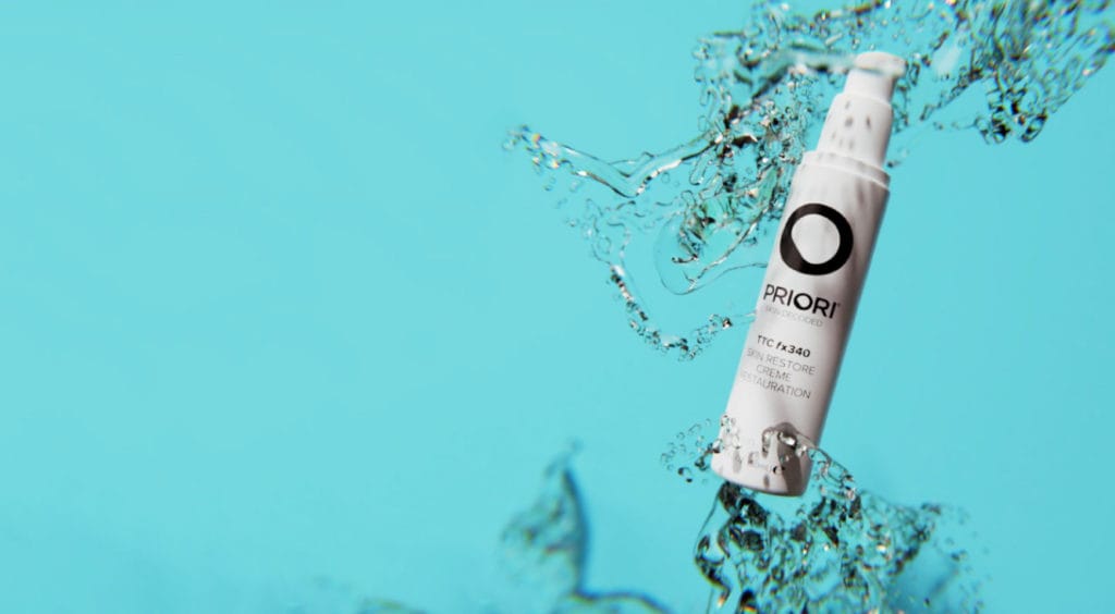 Skin Restore Creme caught in a splash of water against turquoise