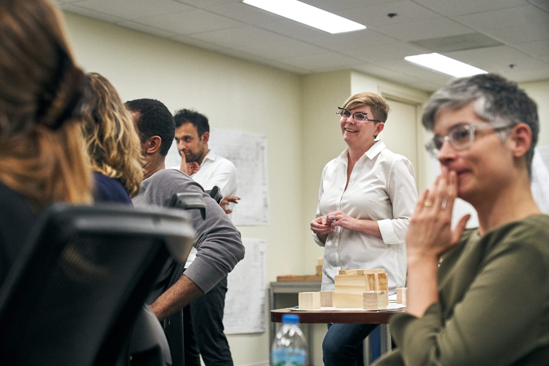 Library staff and the design team around a table model of the exhibition floor