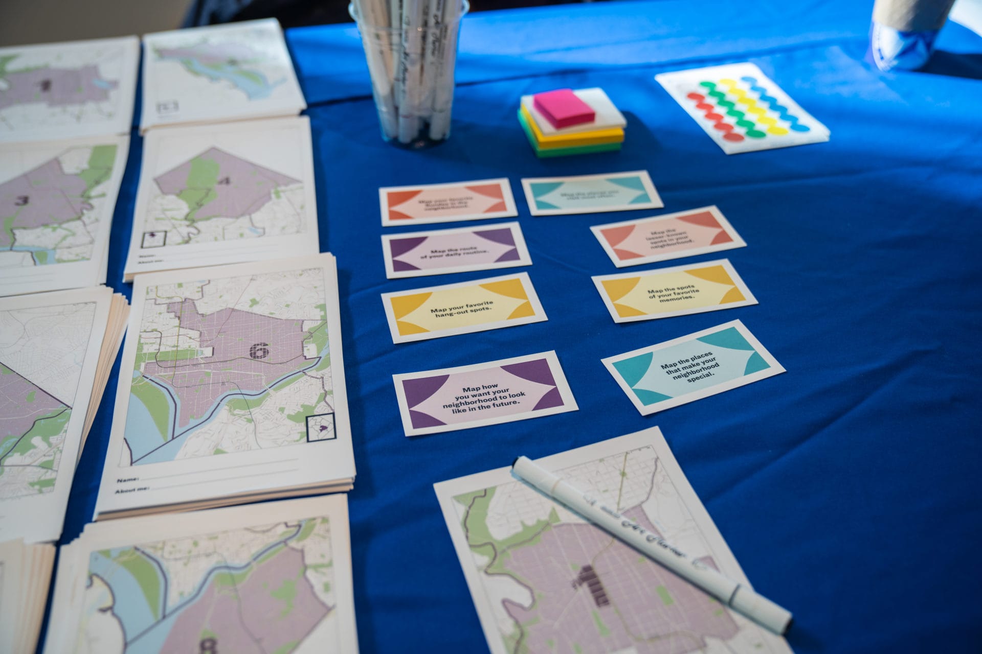 Ward maps and colored cards laid out on a blue workshop table