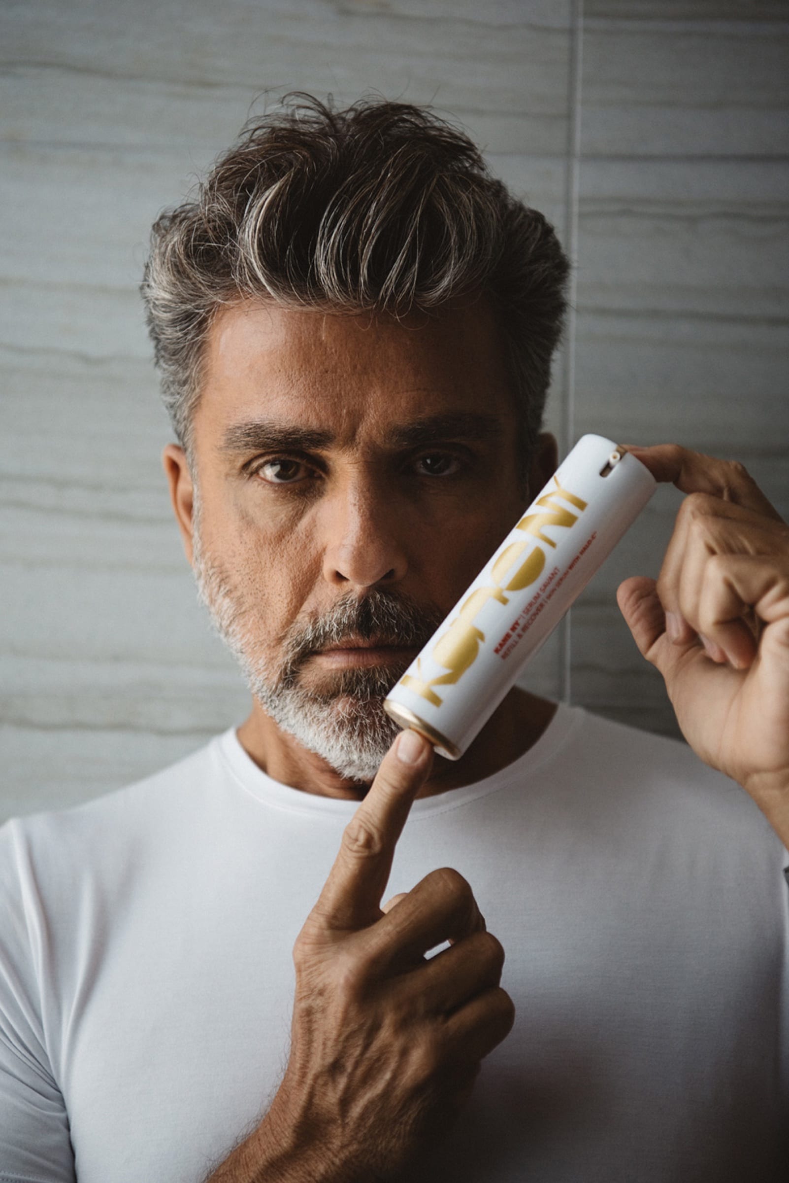 Man in a white T-shirt holding the tube to his face