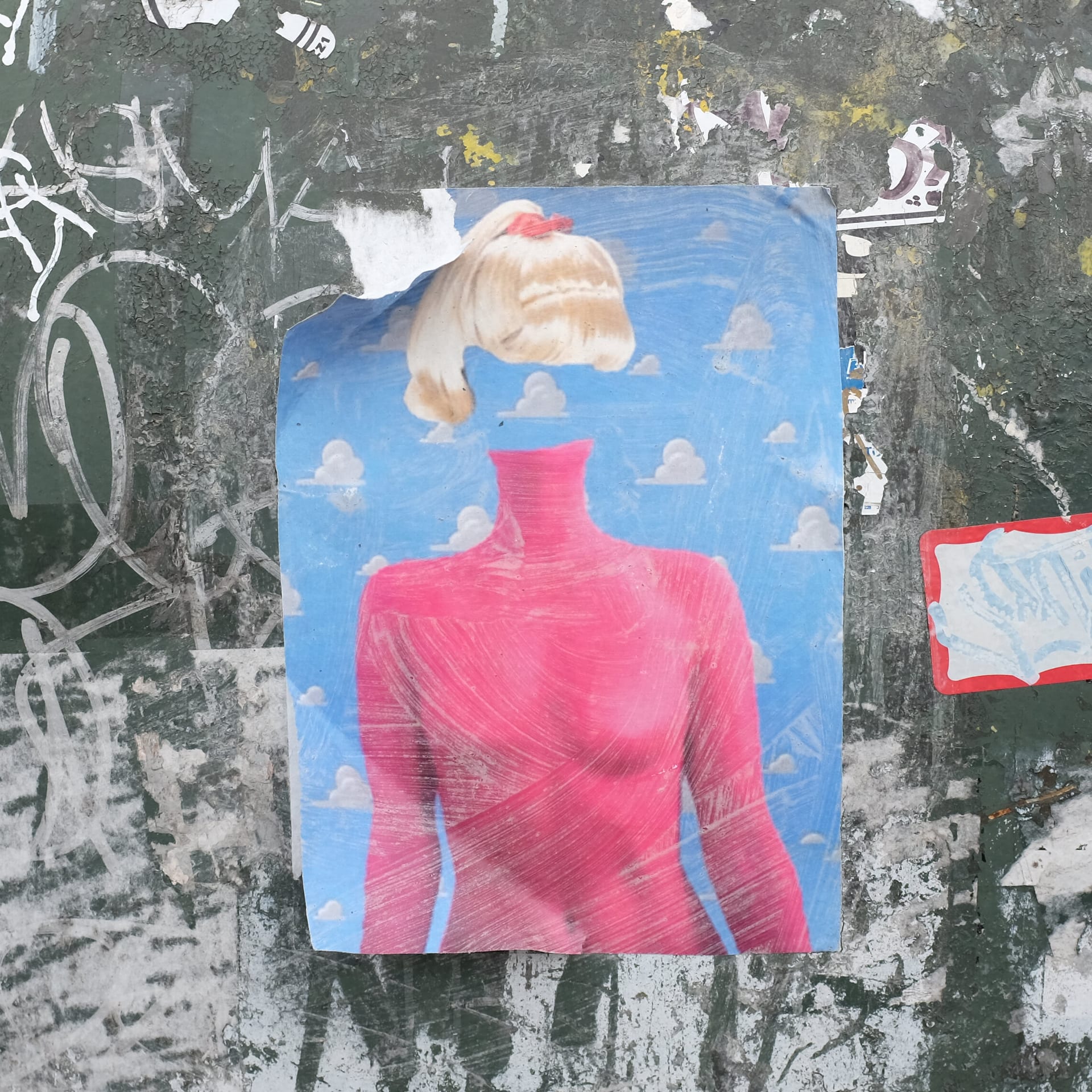 Torn poster of a figure in red on a scratched wall