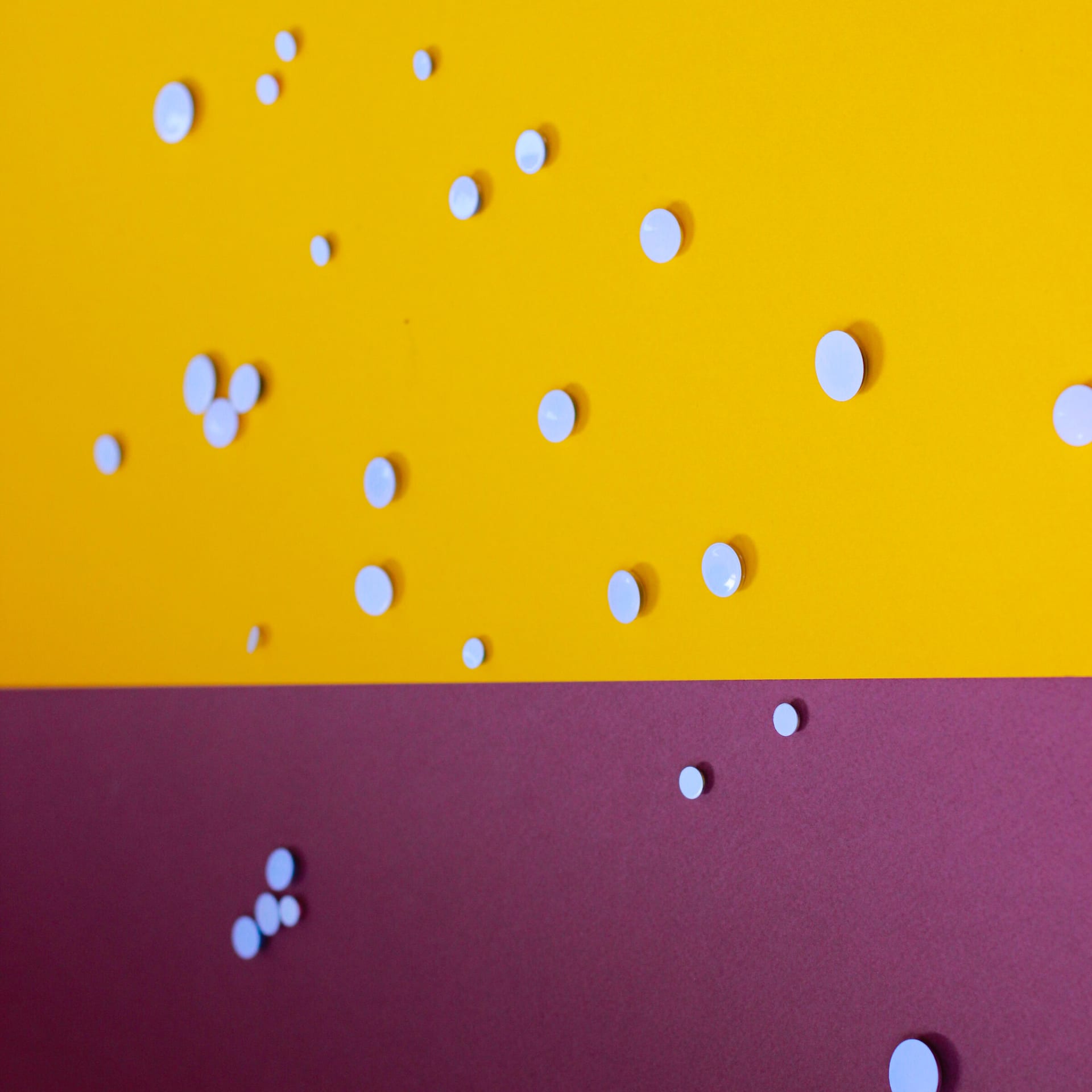 White drops scattered across a yellow and magenta ground