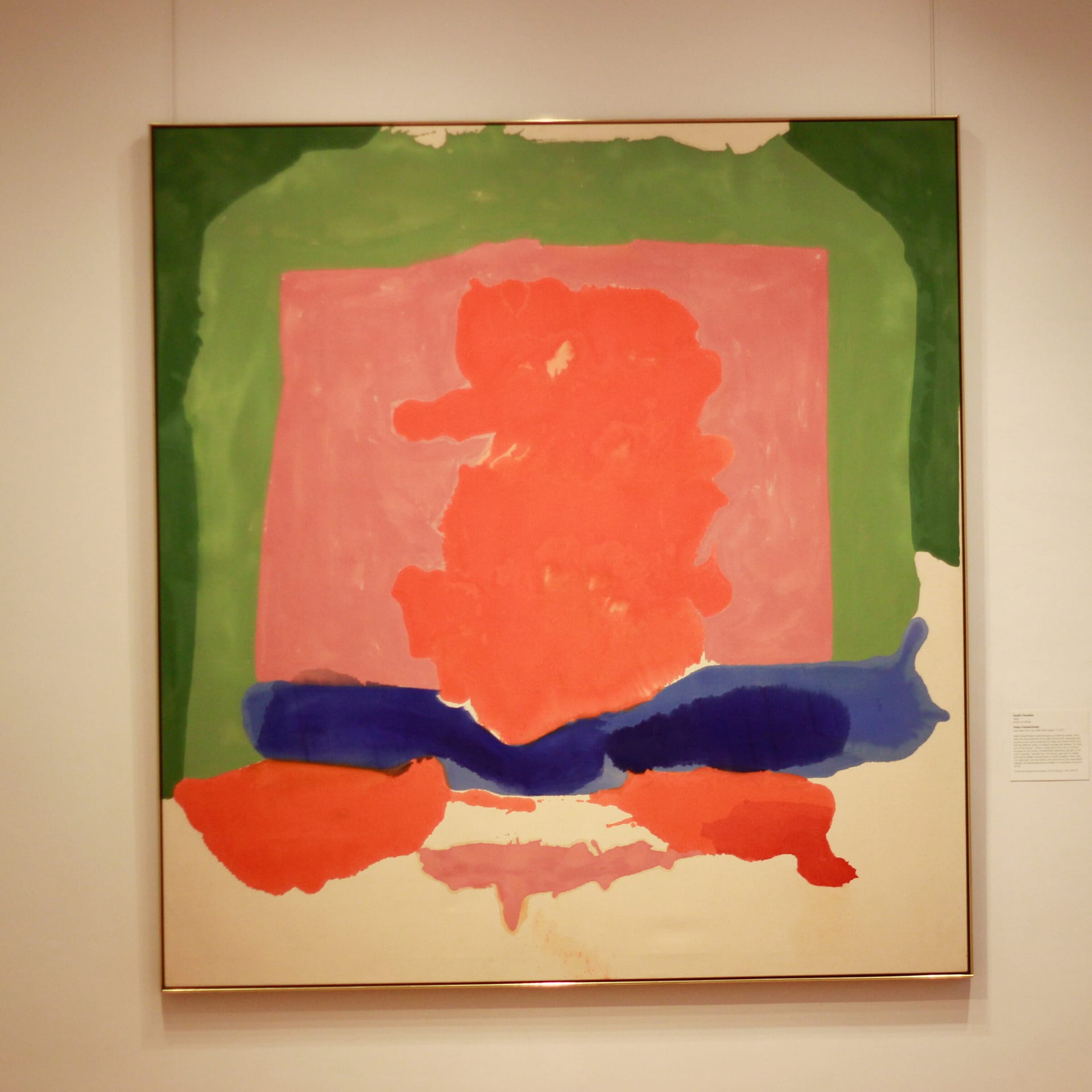 Abstract painting in pink, green, and blue on a gallery wall