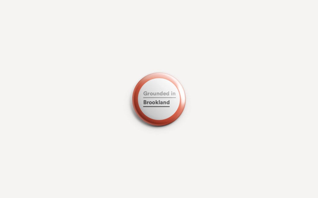 Brookland pin-board takeaway card with the badge mark and pillar headline