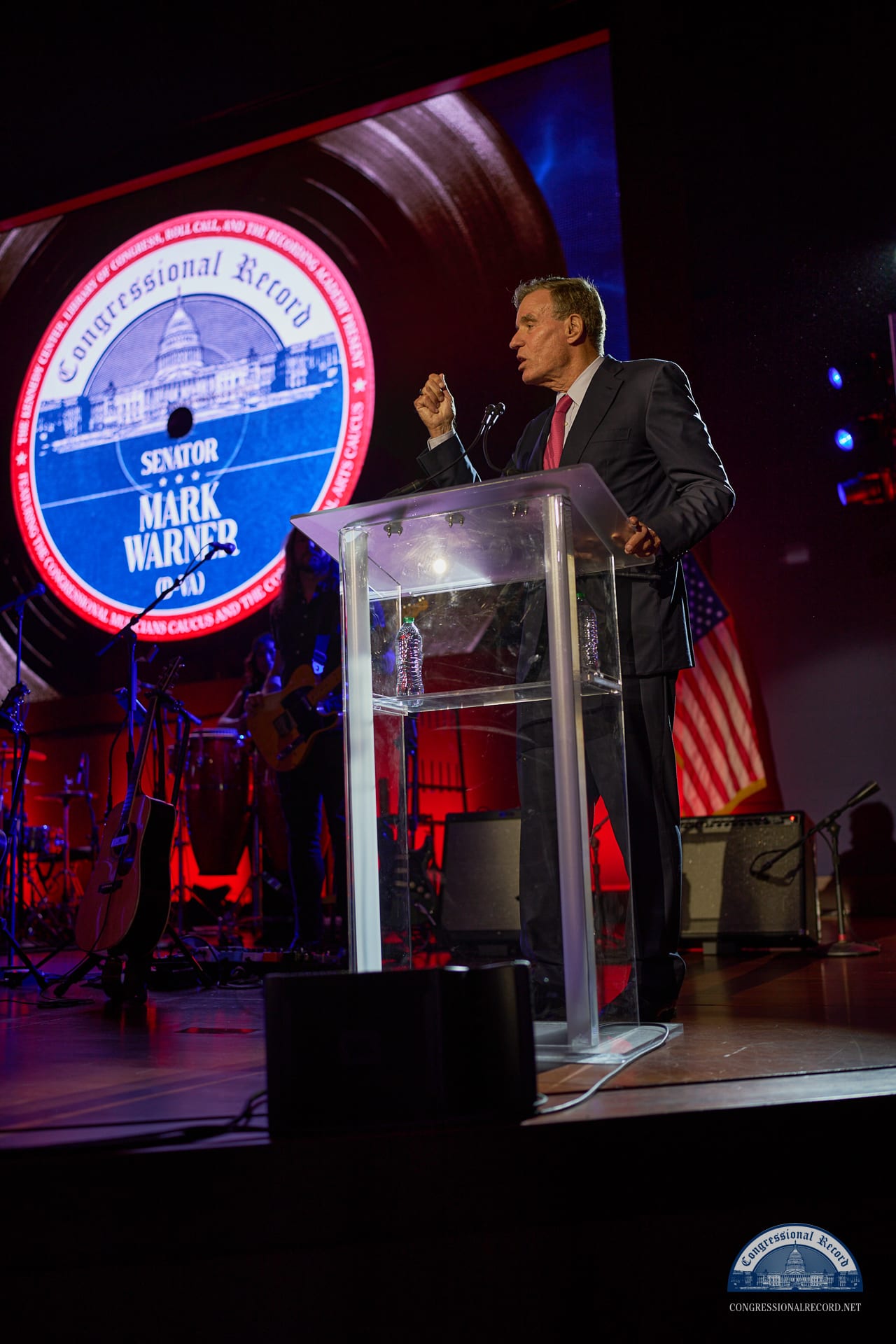 A senator at the podium, the edition seal on the screen behind him