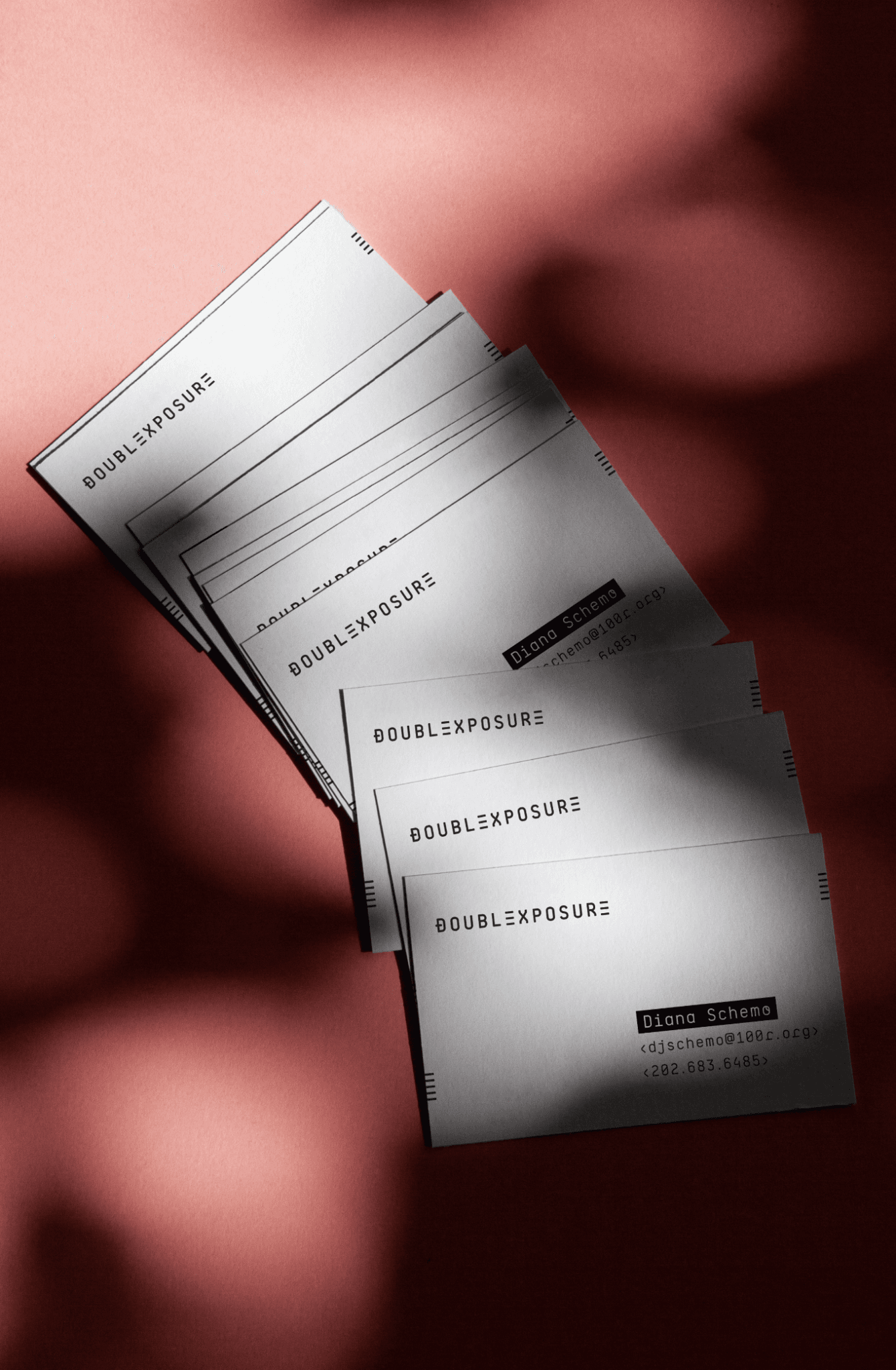 A stack of Double Exposure business cards under red light