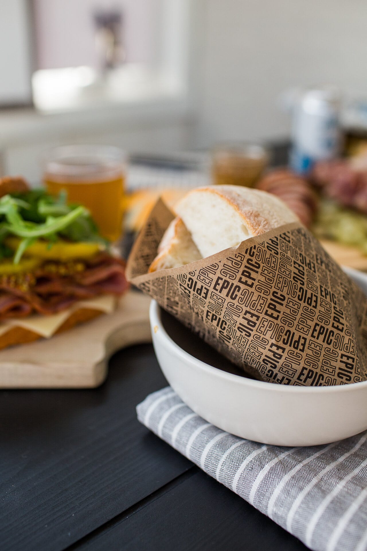 Sandwich in EPIC paper in a white bowl with a beer