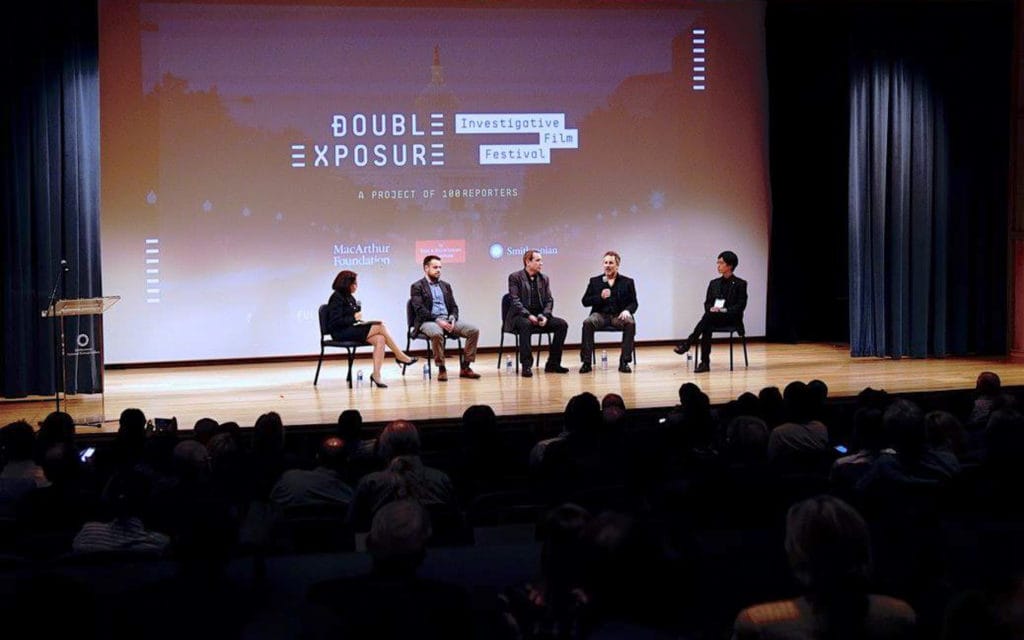 A panel of five on stage under the festival lockup